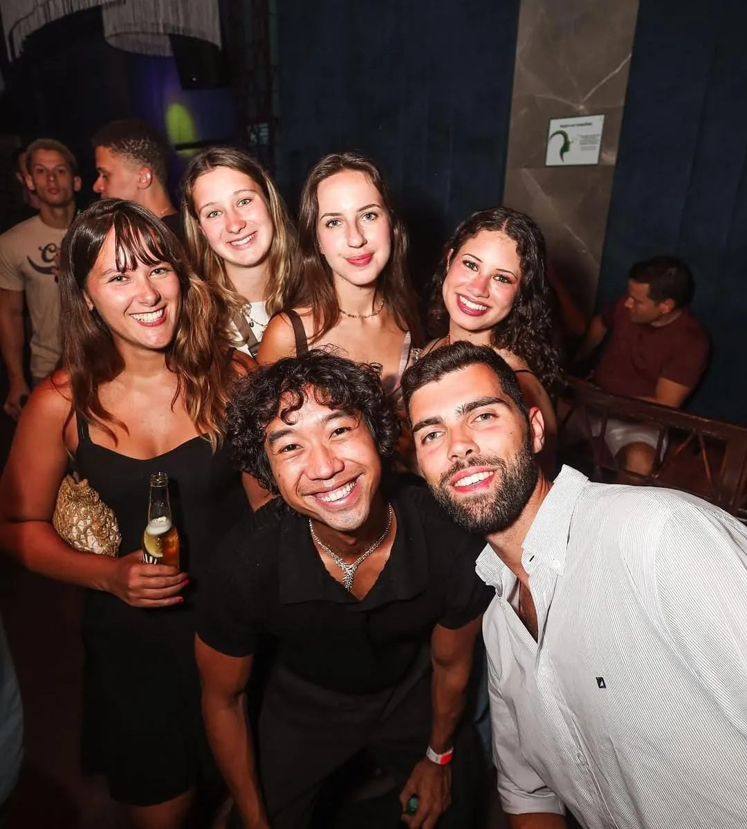 A smiling group of travelers together at a Medellín club
