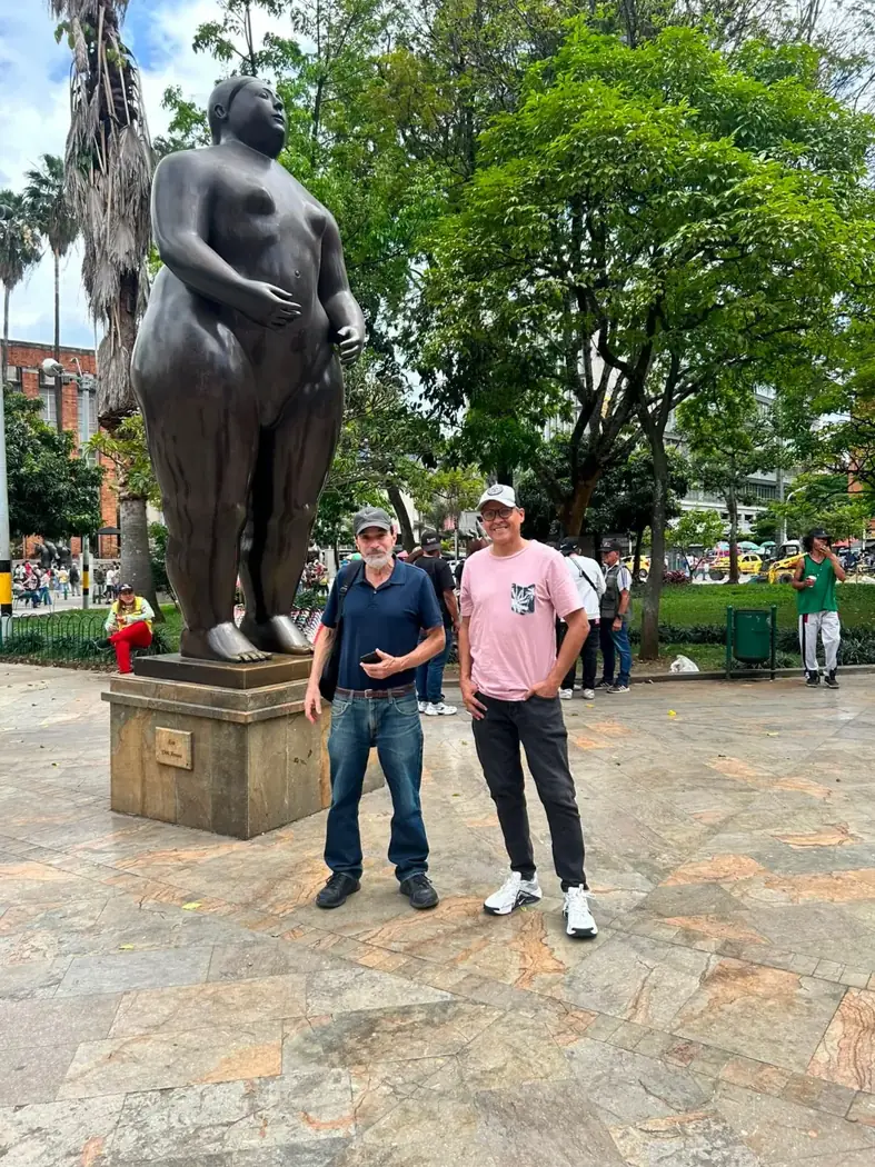 Two travelers beside a Botero bronze sculpture in Botero Park, downtown Medellín