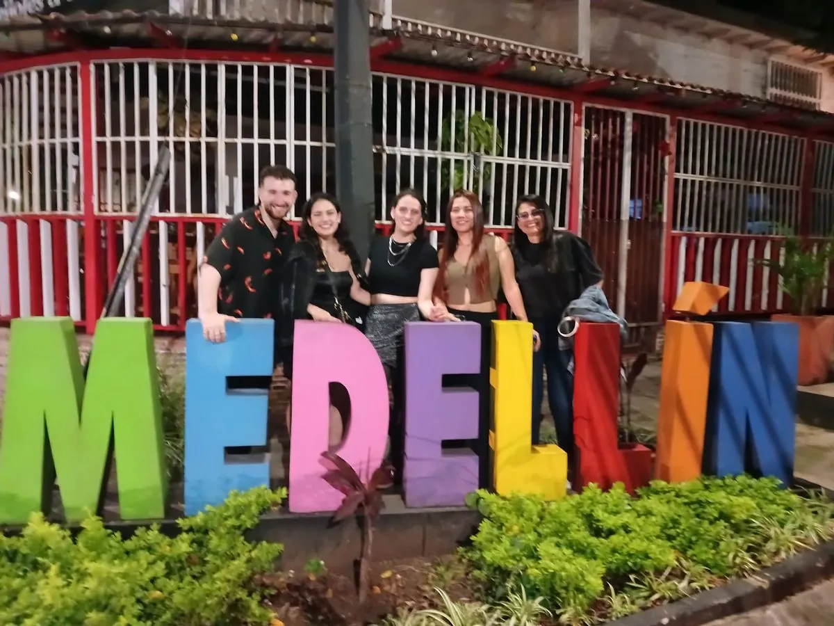 A Vibe Colombia group posing at the colorful MEDELLÍN letters